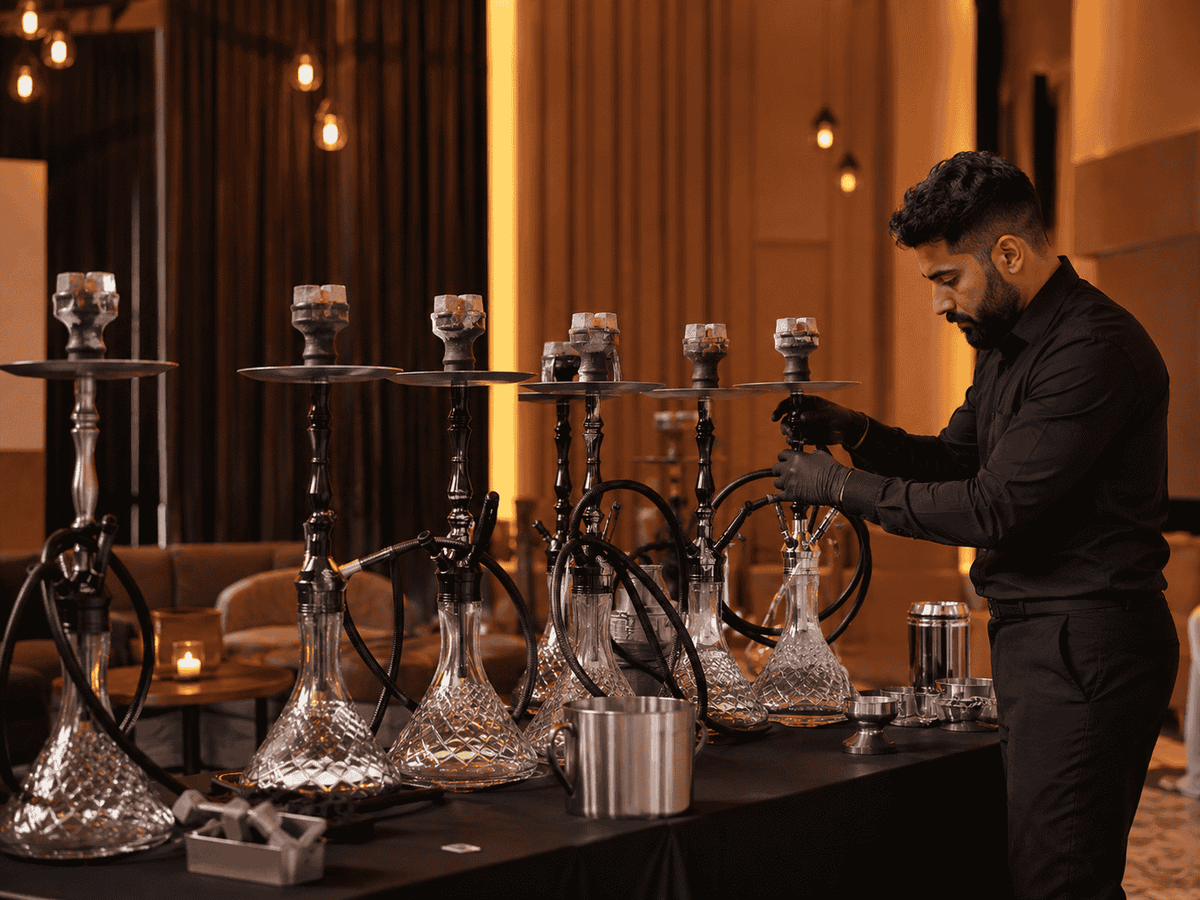 Medewerker bouwt een rij luxe waterpijpen op in een sfeervolle lounge, shisha huren voor een feest met kant-en-klaar geleverde waterpijpen