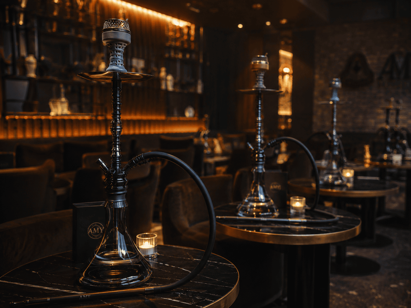 Sfeervolle, donkere shisha lounge met opgetuigde waterpijpen op de tafels en kaarslicht. Een complete shisha ervaring voor gasten in horeca en lounges.