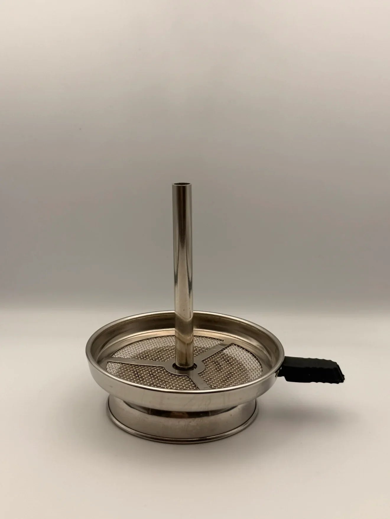 Universele RVS hotscreen liggend op een shisha tabakskop, gemaakt van roestvrij staal