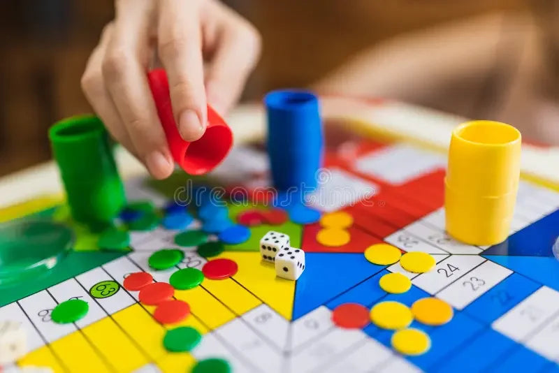Vier spelers rond het glazen Parchi-bord op tafel tijdens een spelavond